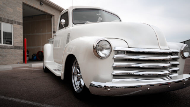 vintage white Chevy Truck outside of Garage Slick