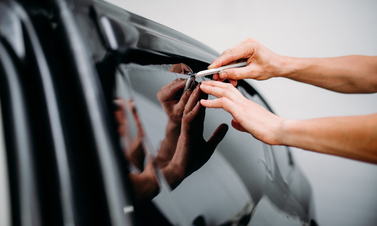 specialist applying tint film to car window